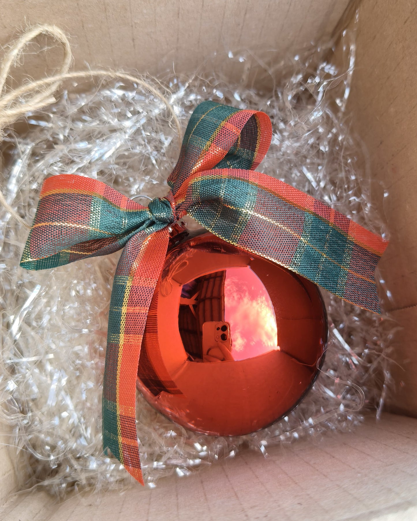 Dettaglio sfera natalizia artigianale in vetro con personalizzazione e fiocco decorativo tartan