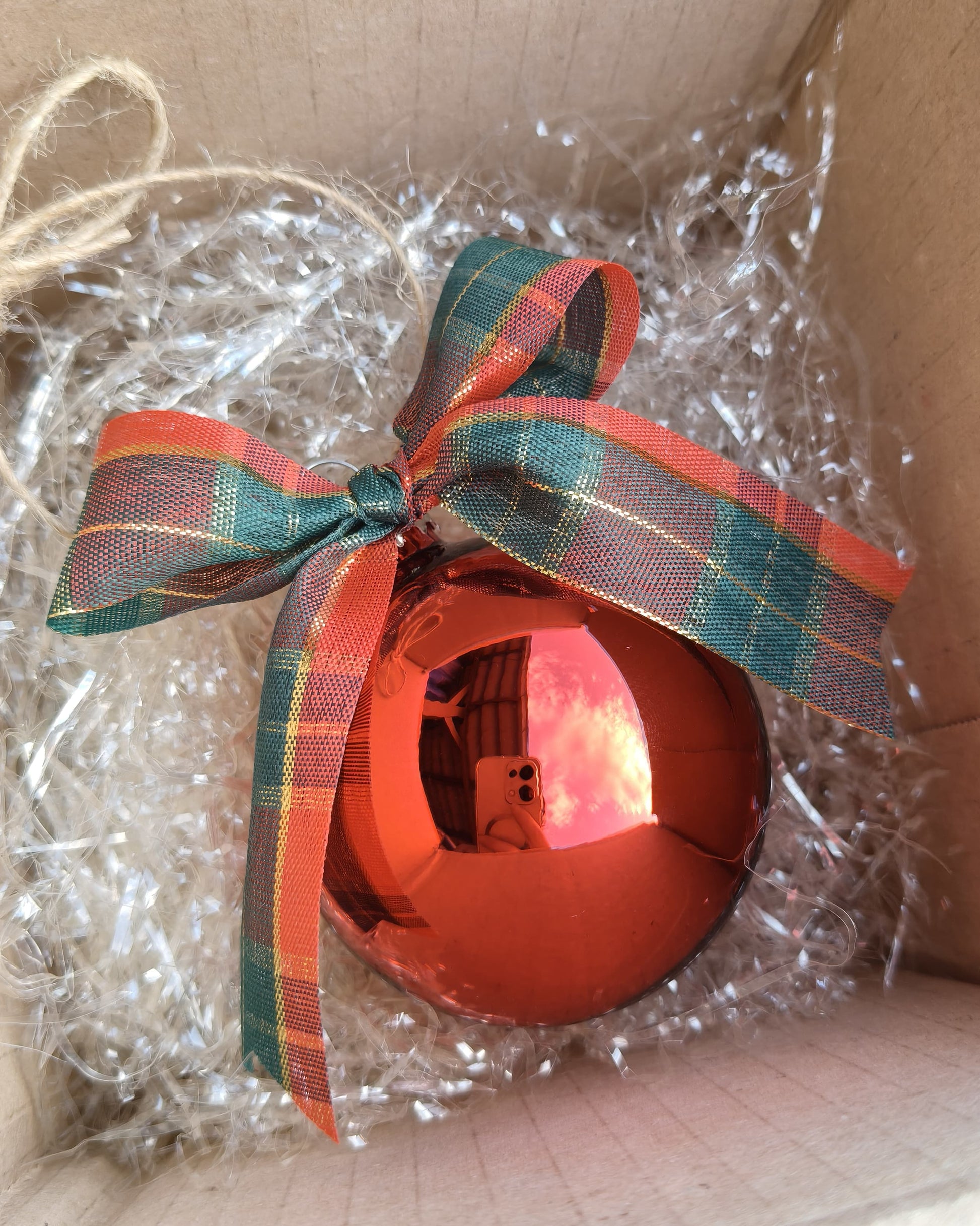 Dettaglio sfera natalizia artigianale in vetro con personalizzazione e fiocco decorativo tartan